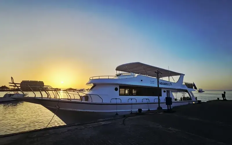 Bateau de plongée amarré au quai au coucher du soleil sur mer