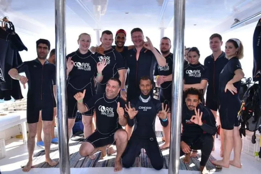 Groupe de plongeurs souriants sur un bateau de plongée ensoleillé