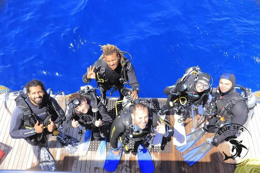 Plongeurs souriants sur le pont d'un bateau de plongée en mer
