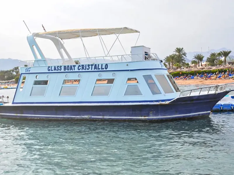 Bateau à fond de verre bleu et blanc naviguant sur une mer calme
