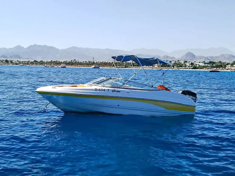 Bateau de plaisance jaune et blanc navigue sur une mer bleue claire