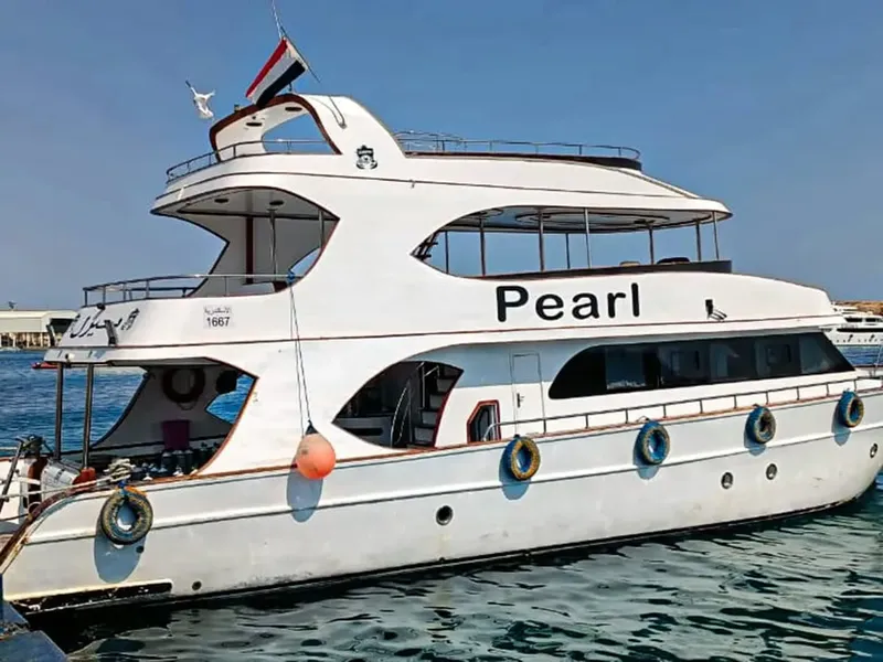 Grand bateau de plongée blanc amarré sur une mer calme et bleue