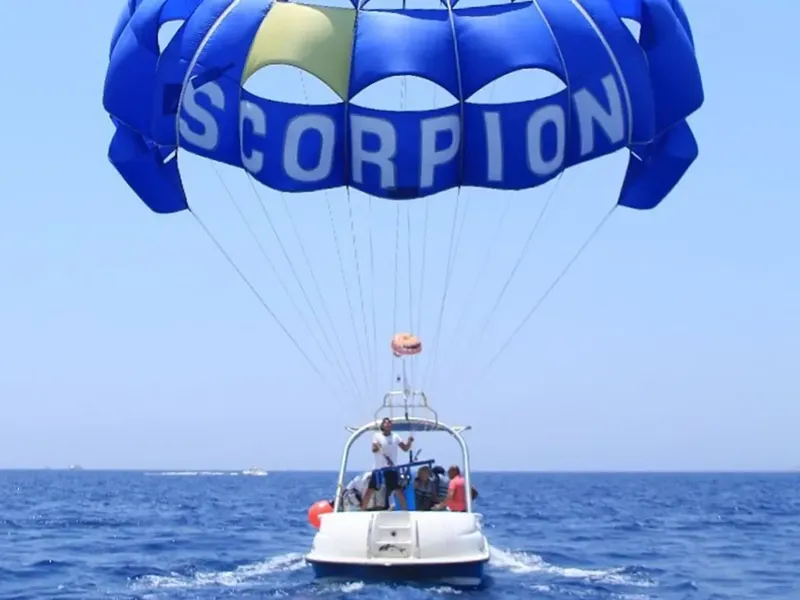 Personnes en parachute ascensionnel tirées par un bateau rapide en mer