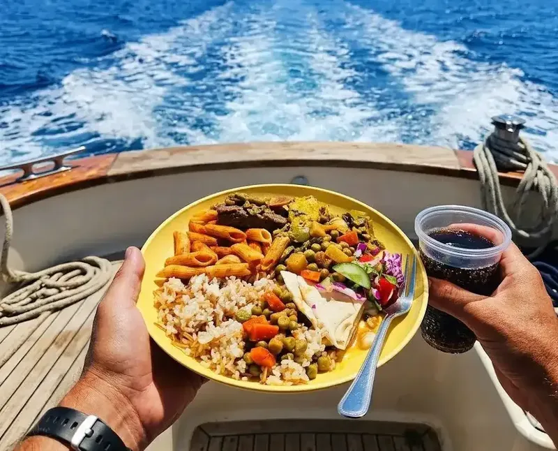 Assiette de nourriture variée tenue sur un bateau en mer