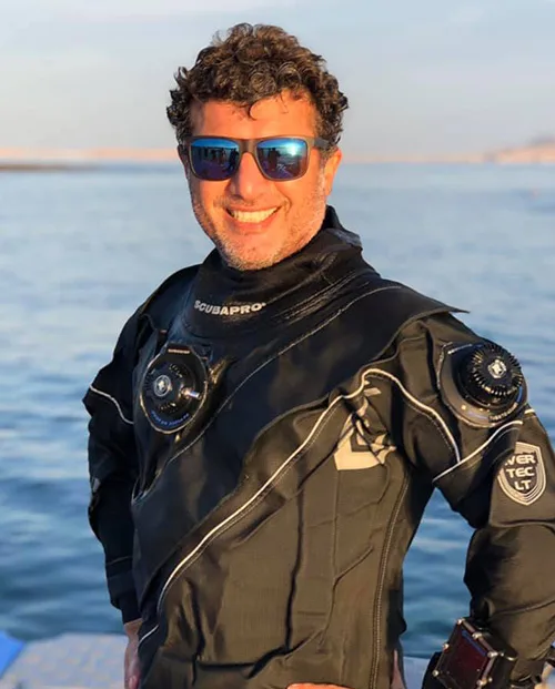 Plongeur souriant portant une combinaison et un détendeur noir