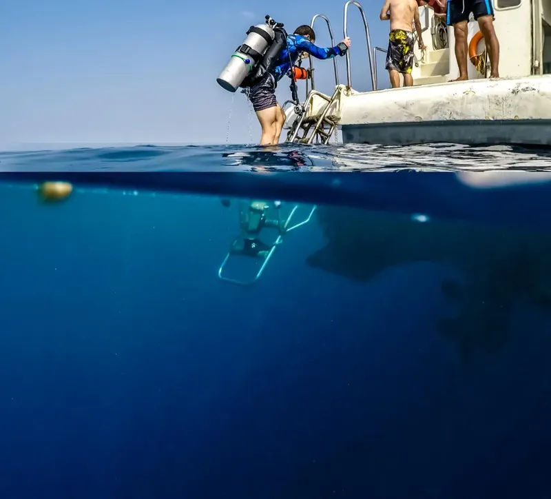 Plongeur s'équipant sur un bateau, préparation à une immersion en mer