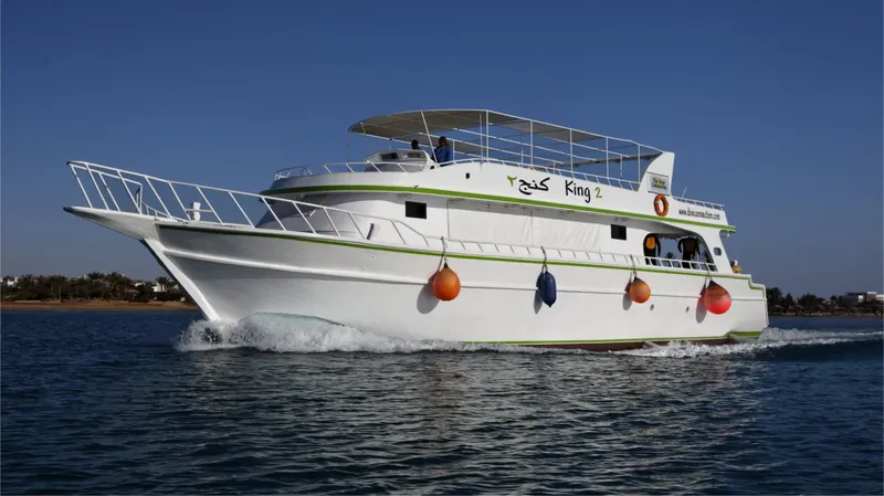 Bateau de plongée blanc naviguant sur une mer bleue ensoleillée