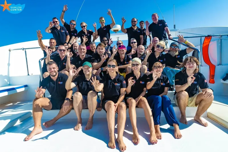 Groupe de plongeurs souriants sur le pont d'un bateau ensoleillé