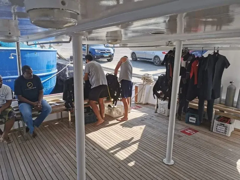 Préparation de matériel de plongée sur le pont d'un bateau avec des personnes