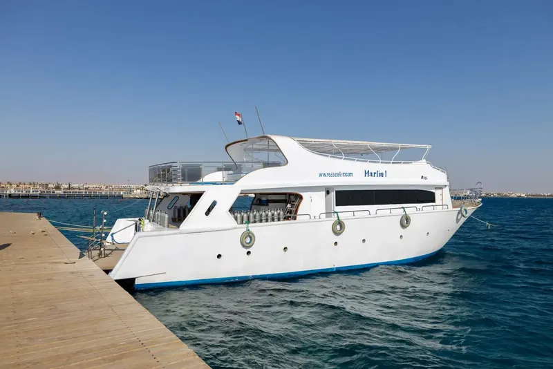 Bateau de plongée amarré à un ponton avec des bouteilles