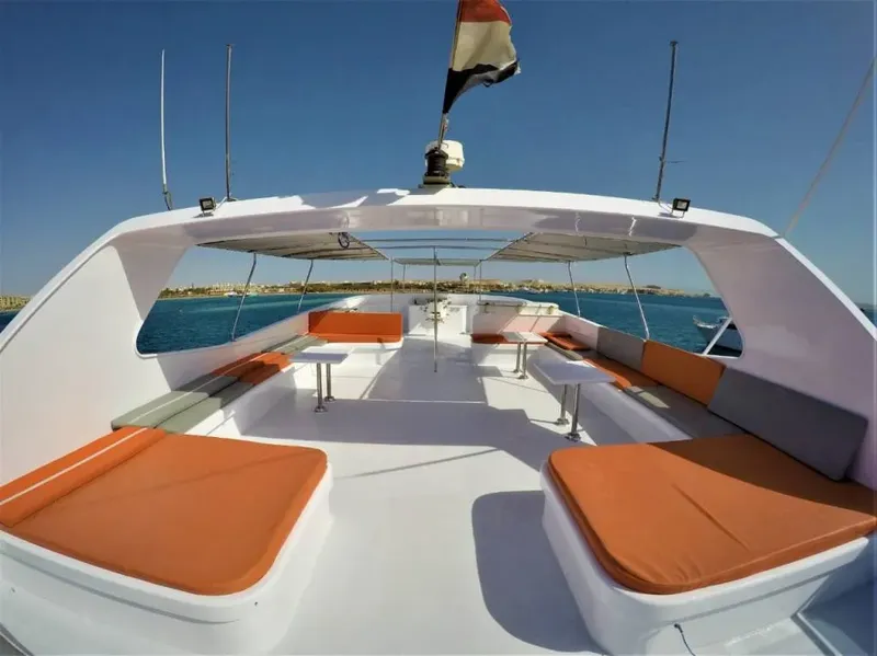 Vue avant d'un bateau de plongée blanc et orange sur l'eau