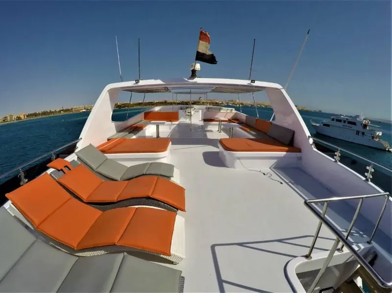 Vue du pont d'un bateau de plongée avec coussins orange et bleu