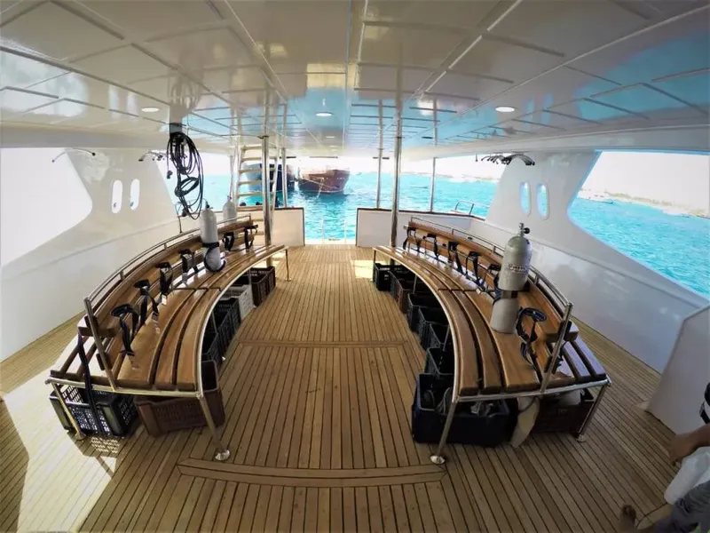 Plateforme arrière d'un bateau de plongée avec des bouteilles et des places