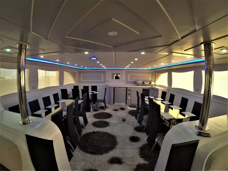 Intérieur d'un bateau de plongée avec tables, sièges et éclairage