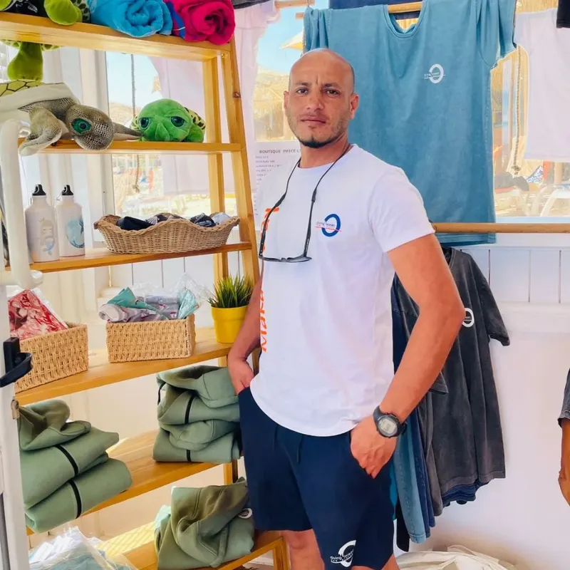 Un homme souriant dans un espace de vente avec du matériel de plongée
