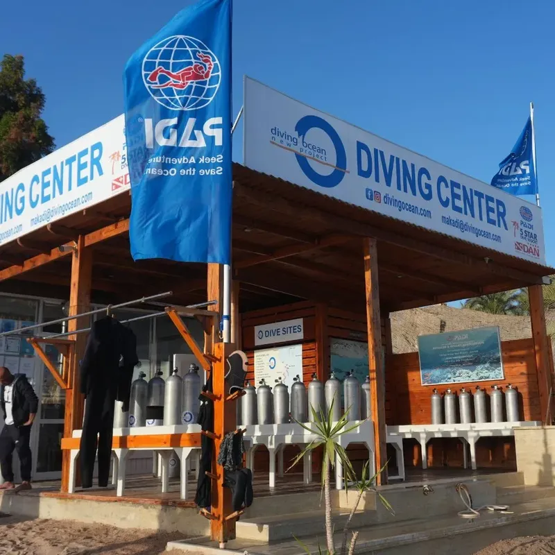 Devanture d'un centre de plongée avec bouteilles et drapeaux bleus