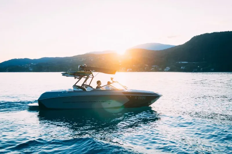 Bateau à moteur navigue sur une eau calme au coucher du soleil