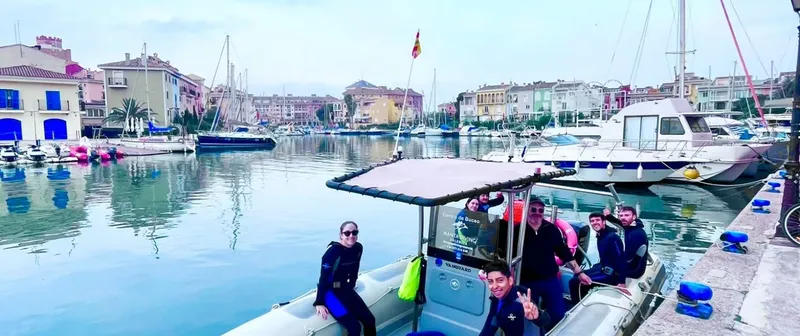 Groupe de plongeurs souriants à bord d'un bateau dans un port