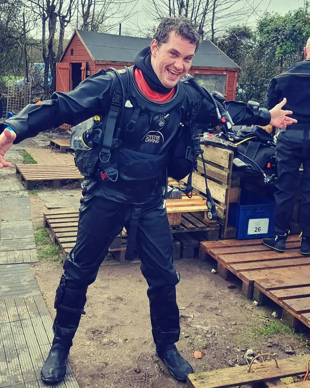 Plongeur souriant en combinaison complète prêt pour une immersion