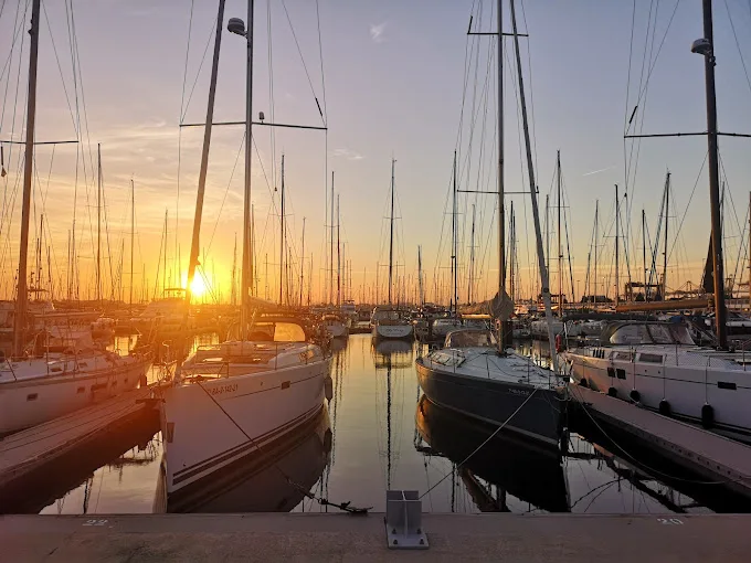 Port de plaisance avec de nombreux voiliers amarrés au coucher du soleil
