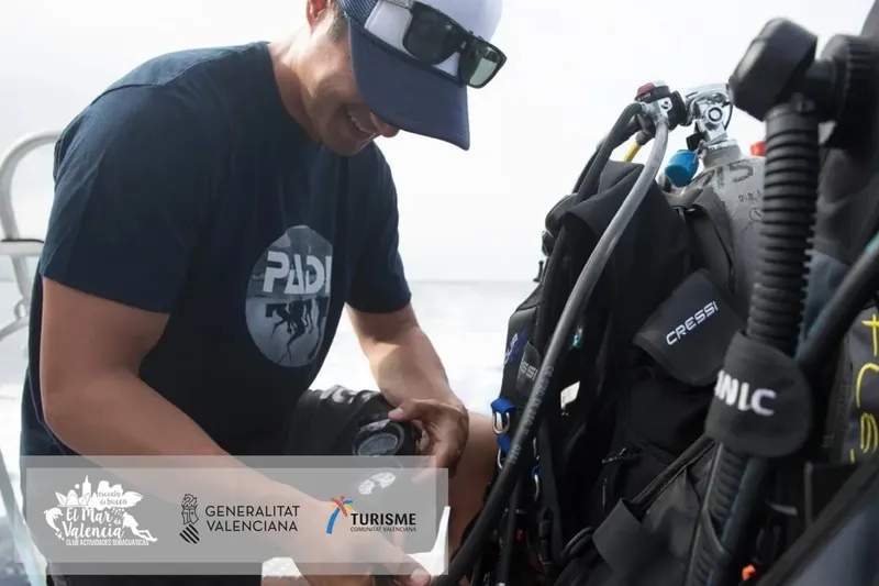 Plongeur préparant son équipement sur un bateau avec des logos divers