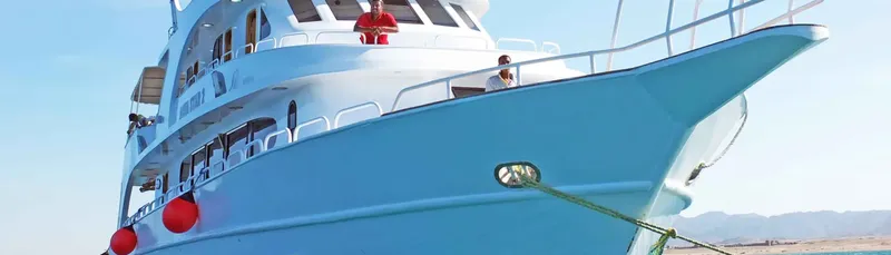 Grand bateau de plongée bleu avec des personnes sur le pont