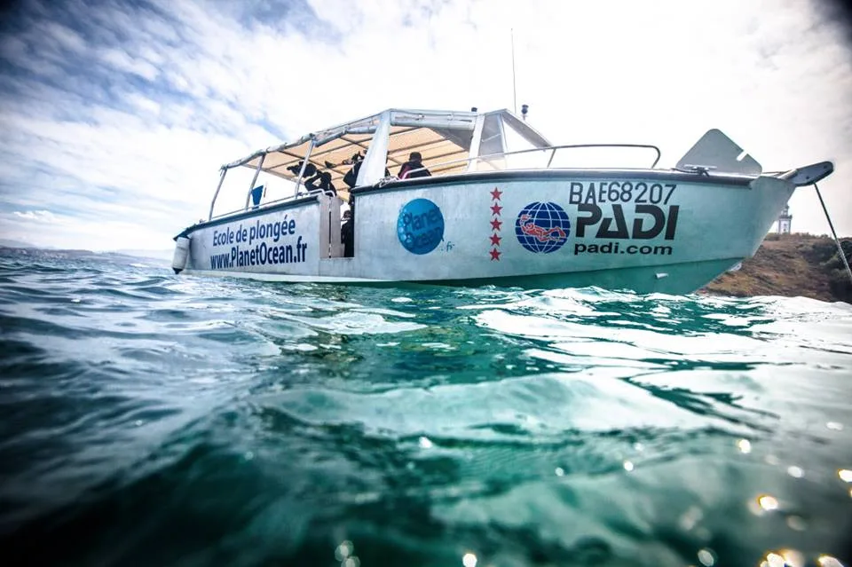 Bateau de plongée avec des plongeurs à bord sur une mer agitée