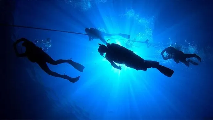 Plongeurs en exploration sous-marine, lumière du soleil filtrant à travers l'eau
