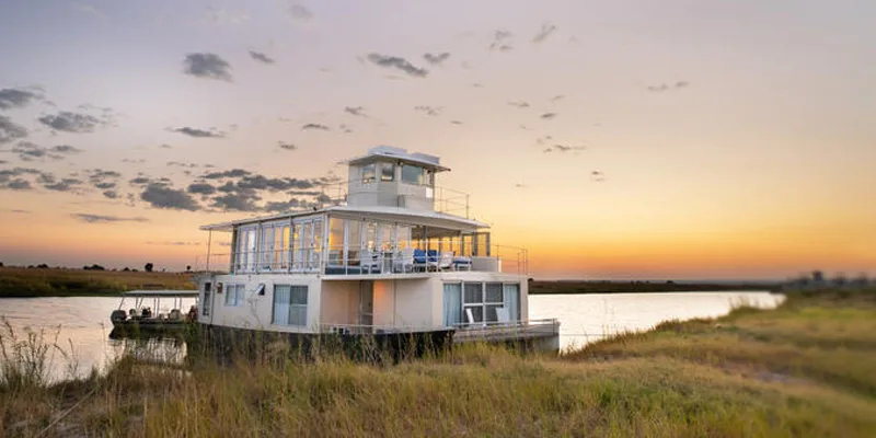 Bateau flottant moderne amarré sur une rivière au coucher du soleil