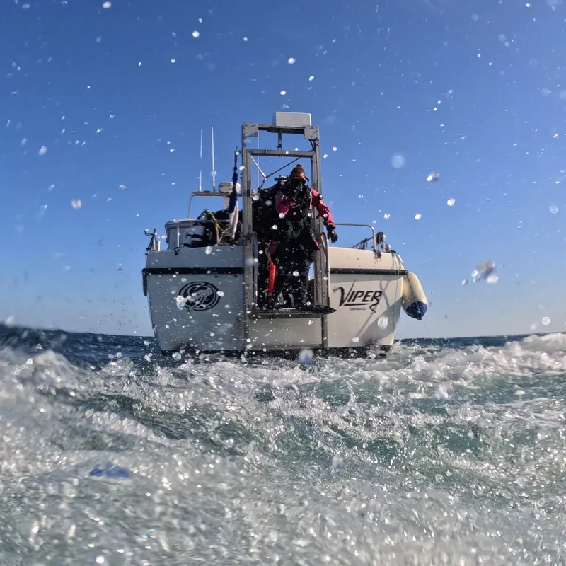 Plongeur s'équipant sur un bateau rapide en pleine mer