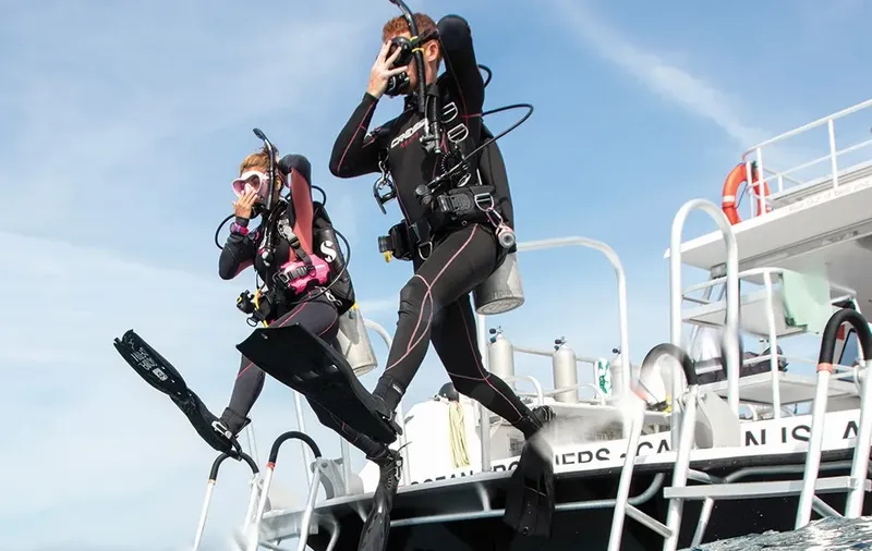 Deux plongeurs s'apprêtent à sauter d'un bateau en mer