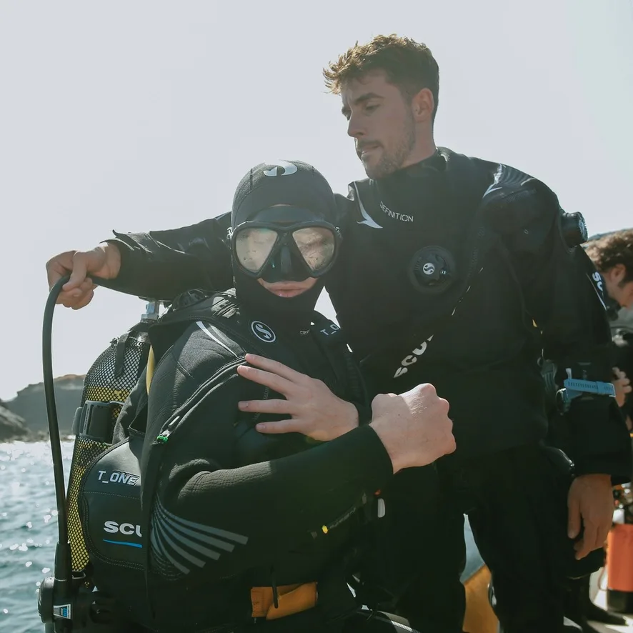 Deux plongeurs équipés se préparent pour une immersion en mer