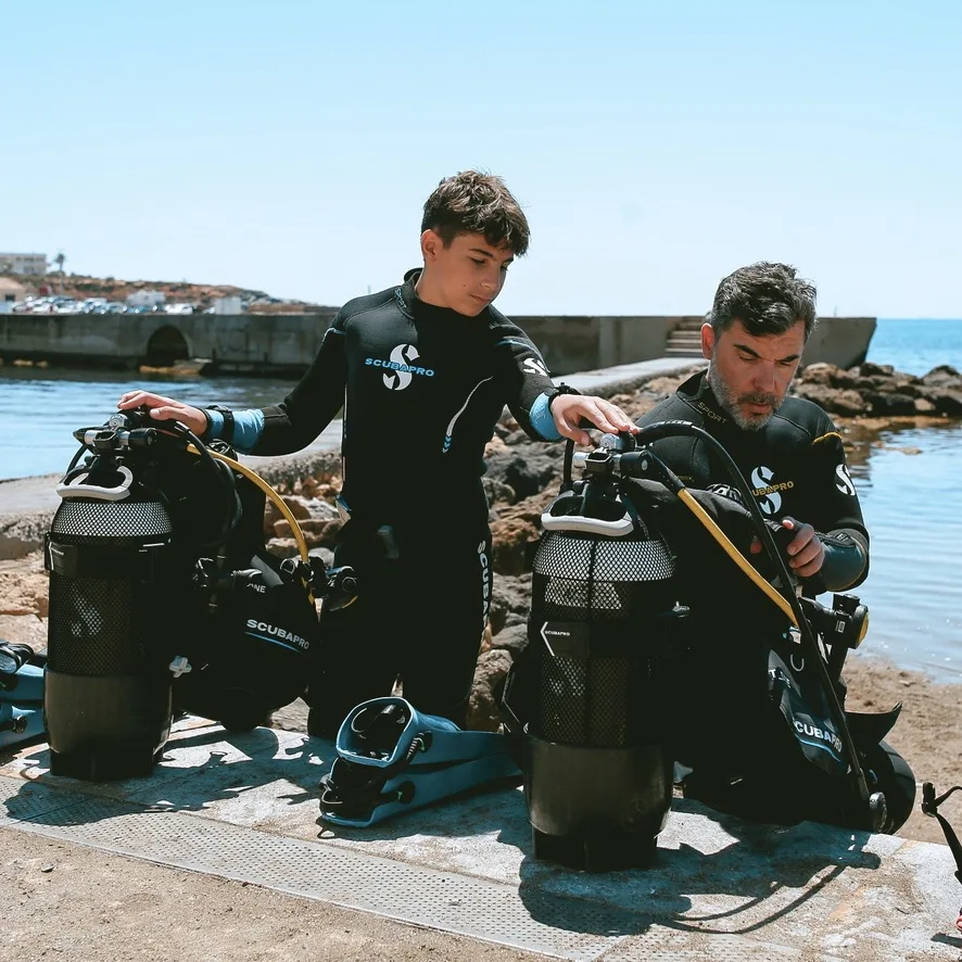 Deux plongeurs vérifient leur équipement avant une immersion en mer
