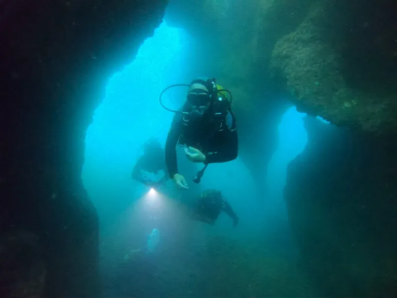 Plongeurs explorent une grotte sous-marine avec une lumière artificielle