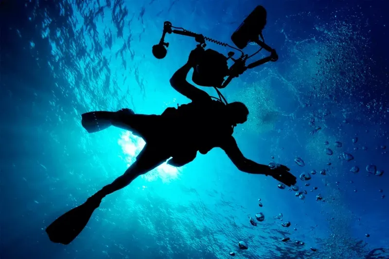 Plongeur silhouette contre la lumière, exploration sous-marine, bulles, bleu profond