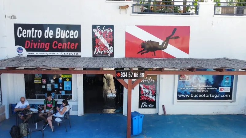 Façade d'un centre de plongée avec des personnes assises devant