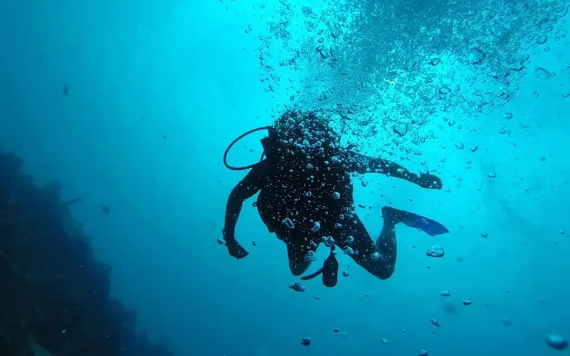 Plongeur en silhouette explore les profondeurs bleues avec des bulles