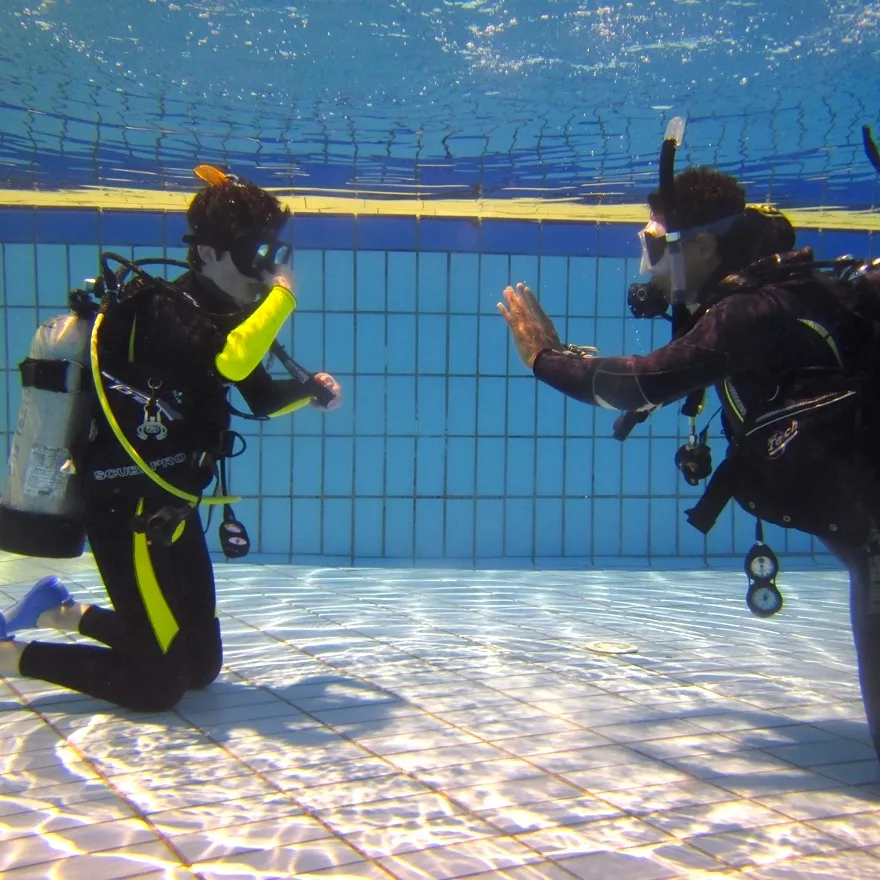 Deux plongeurs en formation s'entraînent dans une piscine claire
