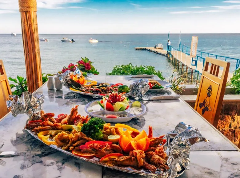 Table garnie de fruits de mer, vue sur la mer et ponton