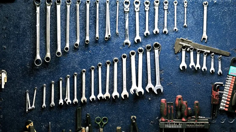 Nombreux outils de clef anglaise accrochés à un mur bleu foncé
