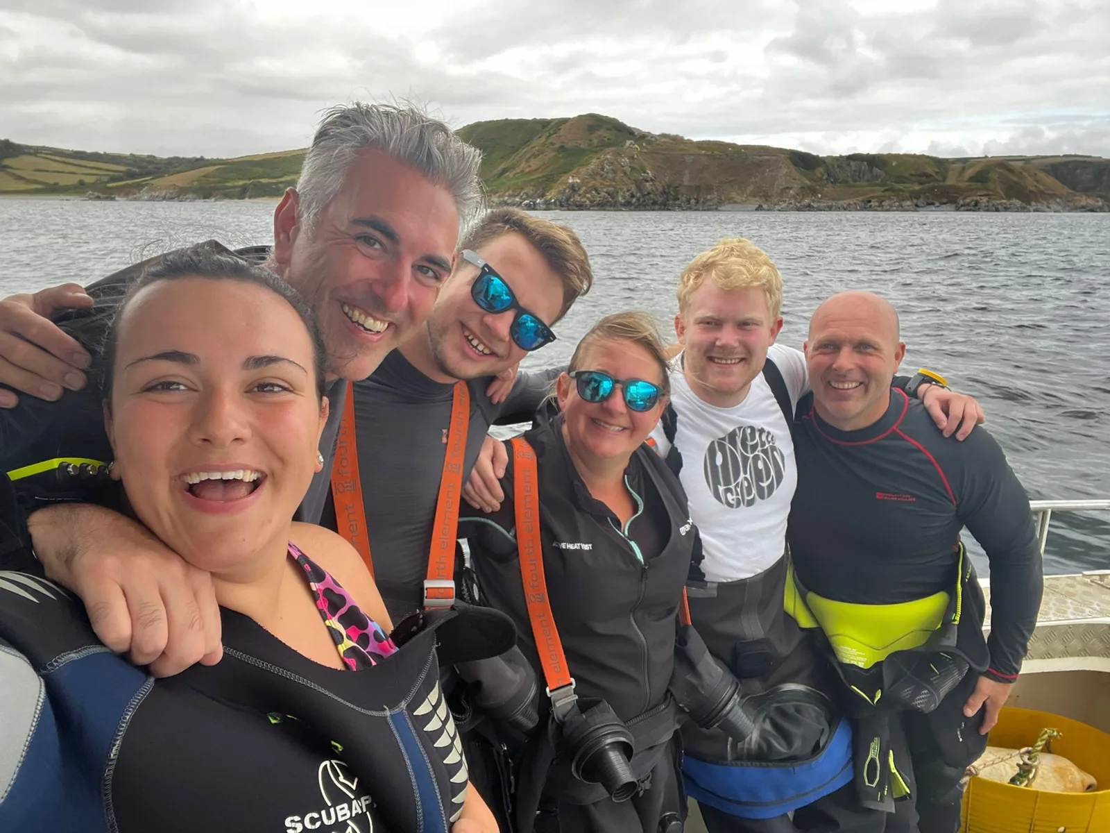 Groupe de plongeurs souriants sur un bateau après une immersion