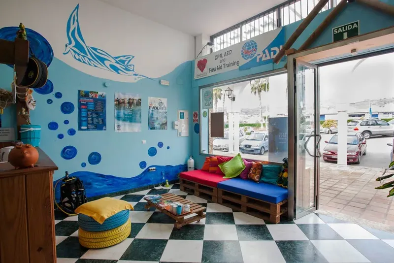 Intérieur d'un centre de plongée avec décoration marine et accès extérieur