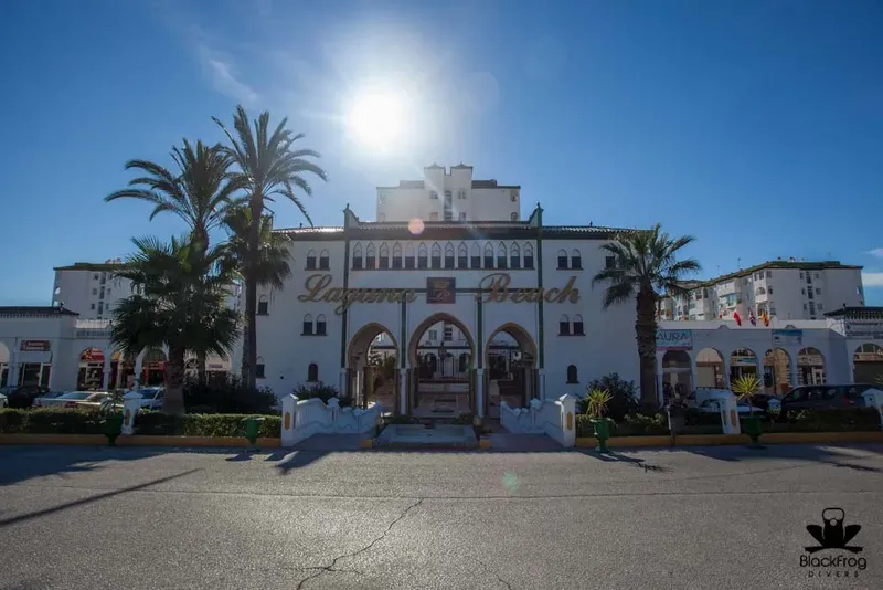 Façade d'un bâtiment blanc avec palmiers et inscription Laguna Beach