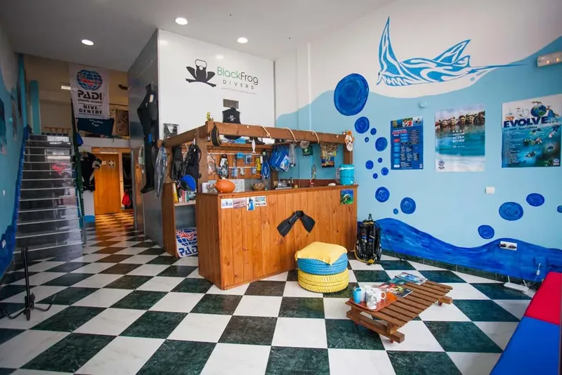 Interieur d'un centre de plongee avec comptoir, equipement et decorations murales
