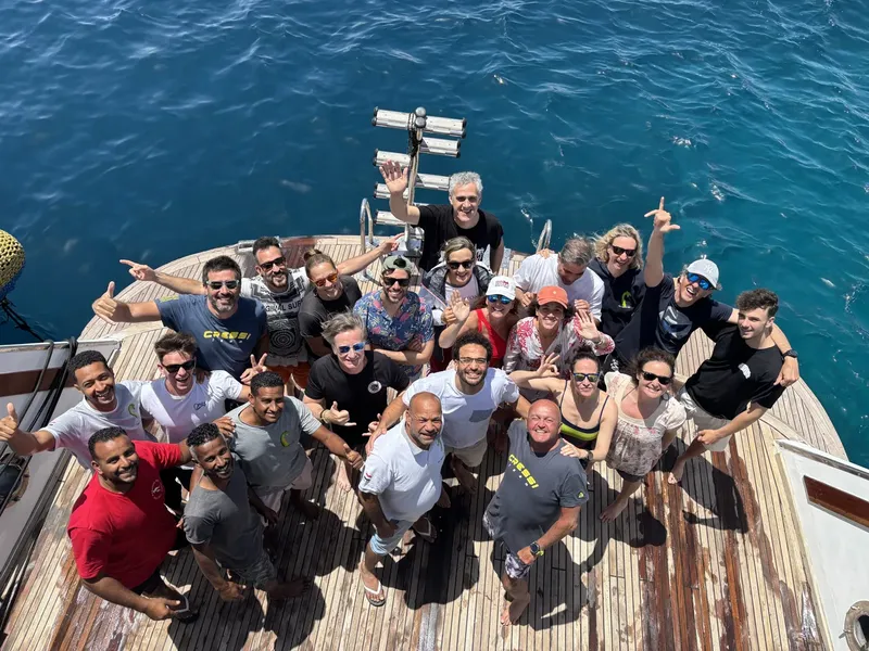 Groupe de plongeurs souriants sur le pont d'un bateau en mer