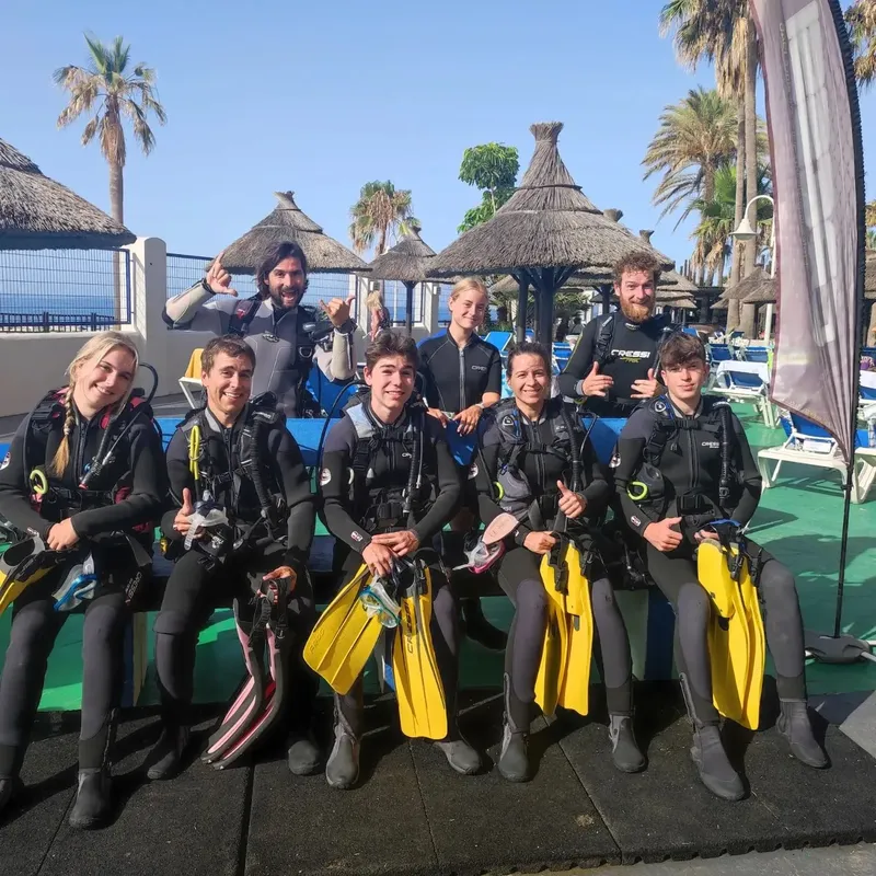 Groupe de plongeurs équipés souriant pour une photo avant immersion