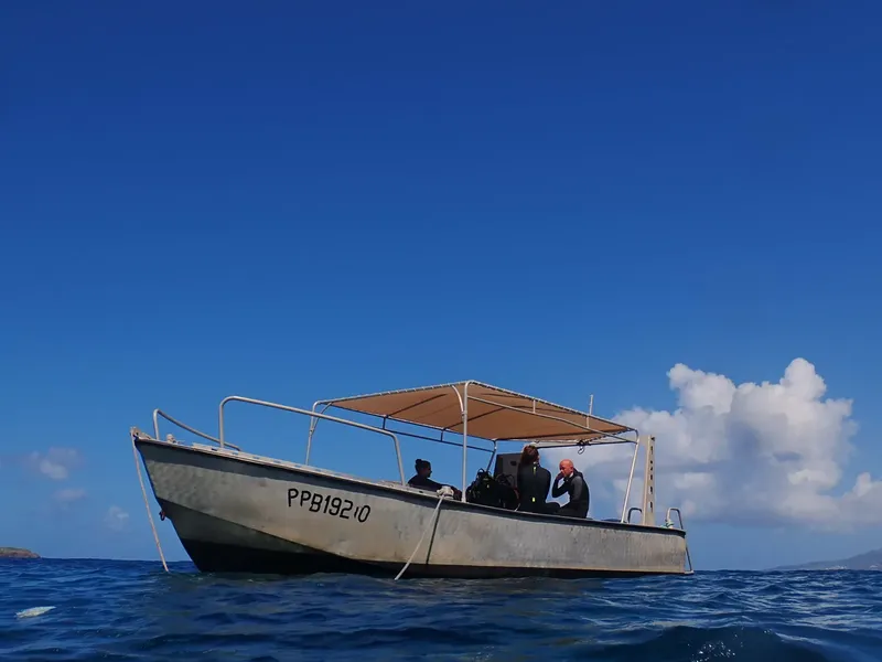 Bateau de plongée avec trois personnes à bord sur mer bleue