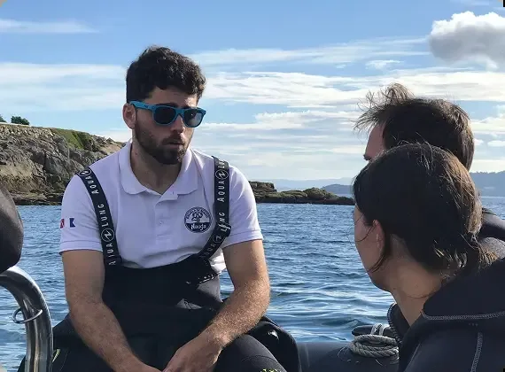 Trois personnes discutent à bord d'un bateau en mer