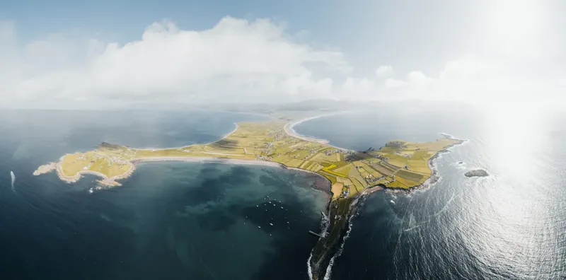 Vue aérienne d'une presqu'île avec des champs et des côtes rocheuses