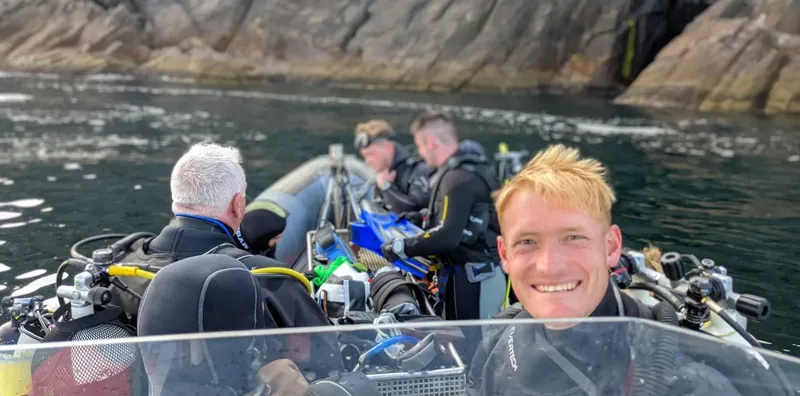 Plongeurs souriants à bord d'un bateau pneumatique en mer